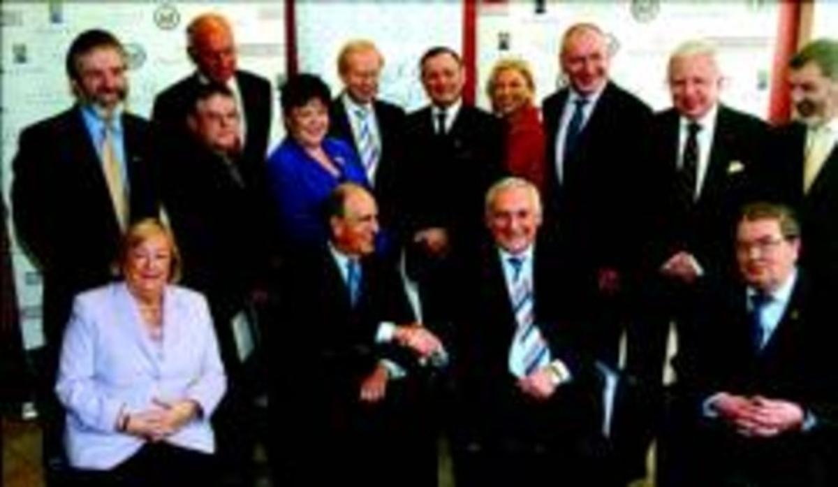 Bertie Ahern y el mediador estadounidense George Mitchell (izquierda) se dan la mano ante otros políticos que negociaron el Acuerdo del Viernes Santo, ayer en Belfast. Arriba, a la izquierda, aparece Gerry Adams.