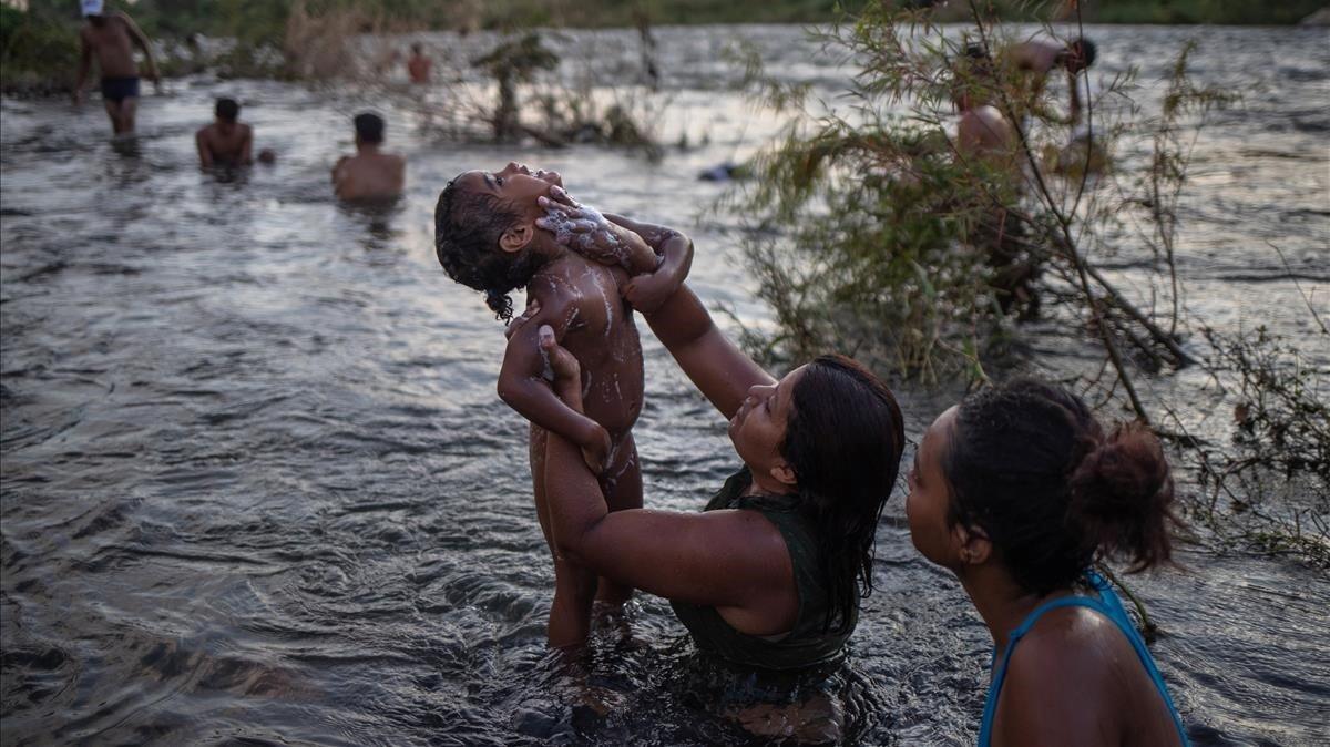 Una mujer baña a su hijo en Pijijiapan.