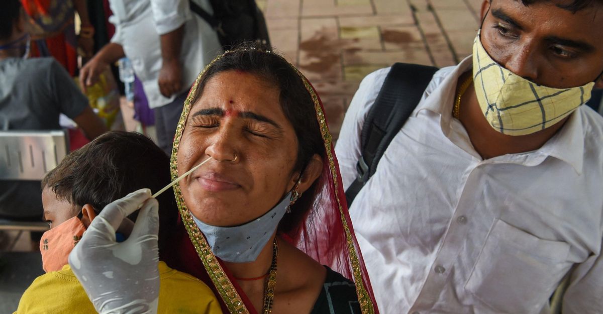 Una sanitaria hace una PCR a una mujer tras bajarse de un tren de larga distancia en Mumbai (India), el 9 de julio. Una sanitaria hace una PCR a una mujer tras bajarse de un tren de larga distancia en Mumbai (India), el 9 de julio.