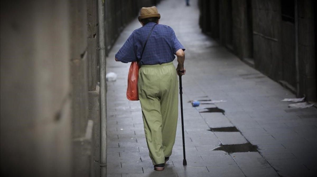Un anciano pasea por una calle de Barcelona. Un anciano pasea por una calle de Barcelona.