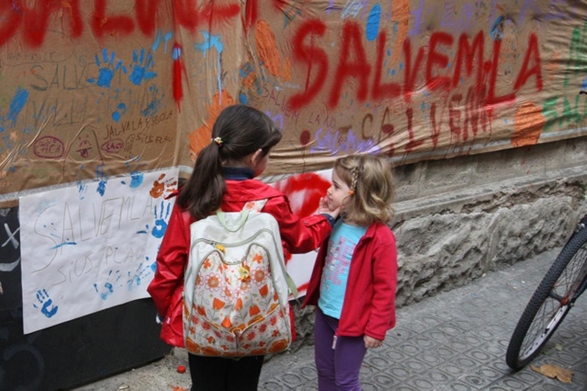 Dos niñas junto al cartel en defensa de la Vil·la Urània, hoy.