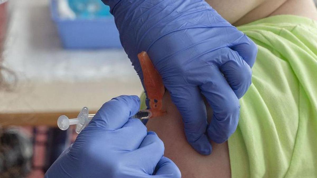 Una enfermera inyecta una vacuna a un niño.