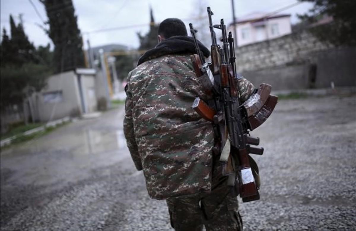 Un soldado de las fuerzas de antodefensa de Nagorno-Karabaj cargado de fusiles antes de firmarse el acuerdo de alto el fuego.