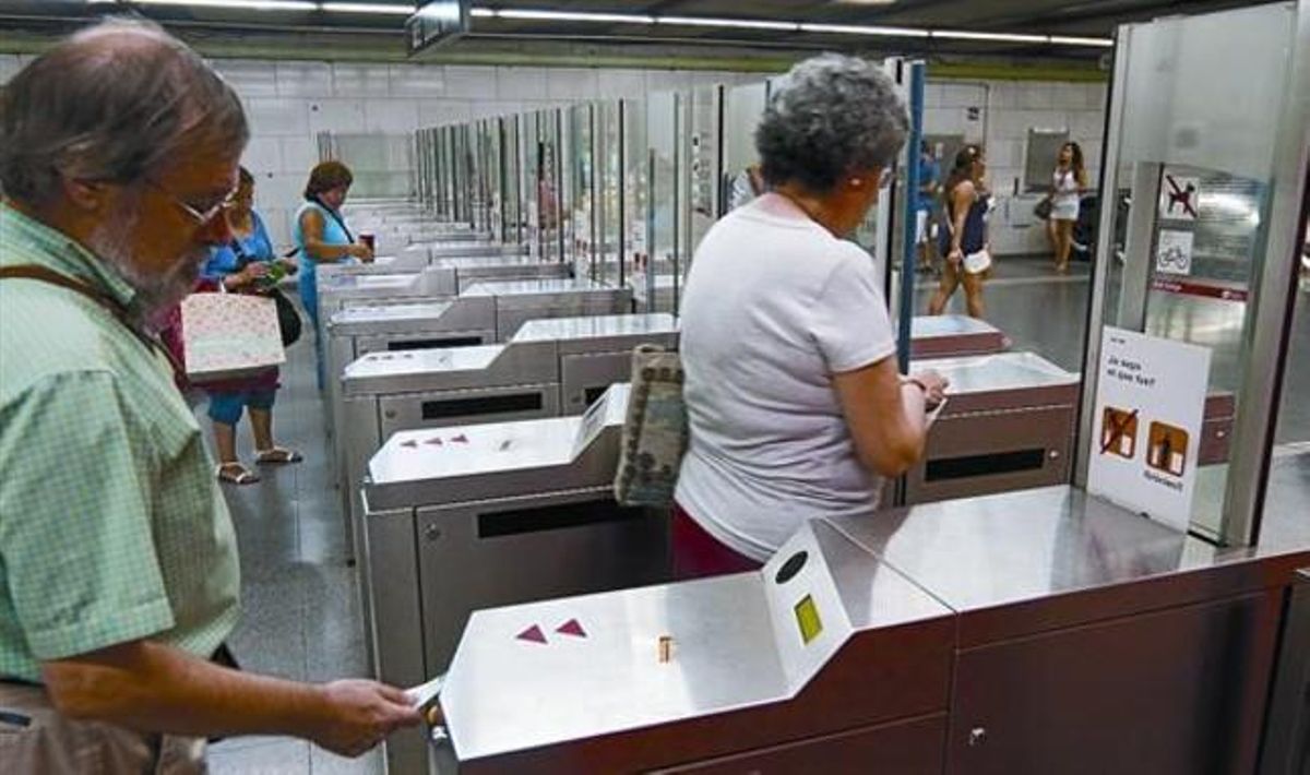 Varios usuarios validan sus billetes en las máquinas de la estación de metro de Plaça Universitat, en Barcelona, ayer. Varios usuarios validan sus billetes en las máquinas de la estación de metro de Plaça Universitat, en Barcelona, ayer.