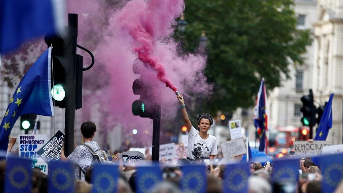 Un manifestante anti-Brexit libera humo de color afuera de las Casas del Parlamento en Londres.