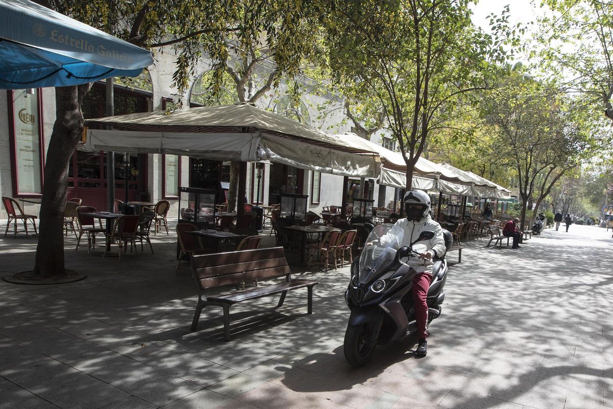 Una moto circula por la peatonal Enric Granados junto a una macroterraza, este miércoles. Una moto circula por la peatonal Enric Granados junto a una macroterraza, este miércoles.