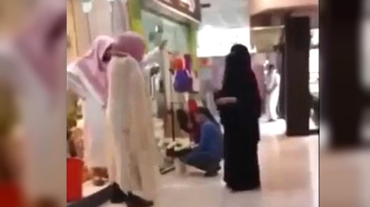 Un miembro de la policía religiosa saudí expulsa de una tienda a una mujer por no llevar guantes.
