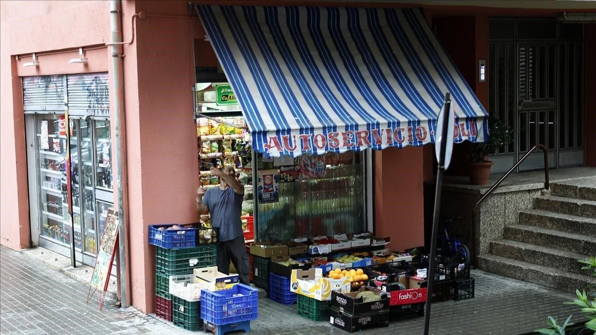 Un vendedor del barrio del Guinardó pone el toldo un día de lluvia Un vendedor del barrio del Guinardó pone el toldo un día de lluvia