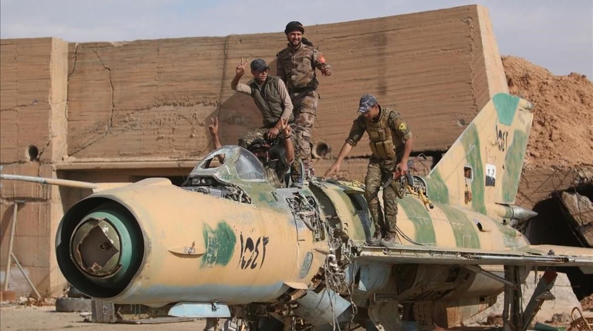 Combatientes de las Fuerzas Democráticas de Sirias posan este domingo subidos a un avión de combate desmantelado tras tomar el control del aeropuerto militar de Tabqa, que estaba en manos del Estado Islámico. Combatientes de las Fuerzas Democráticas de Sirias posan este domingo subidos a un avión de combate desmantelado tras tomar el control del aeropuerto militar de Tabqa, que estaba en manos del Estado Islámico.