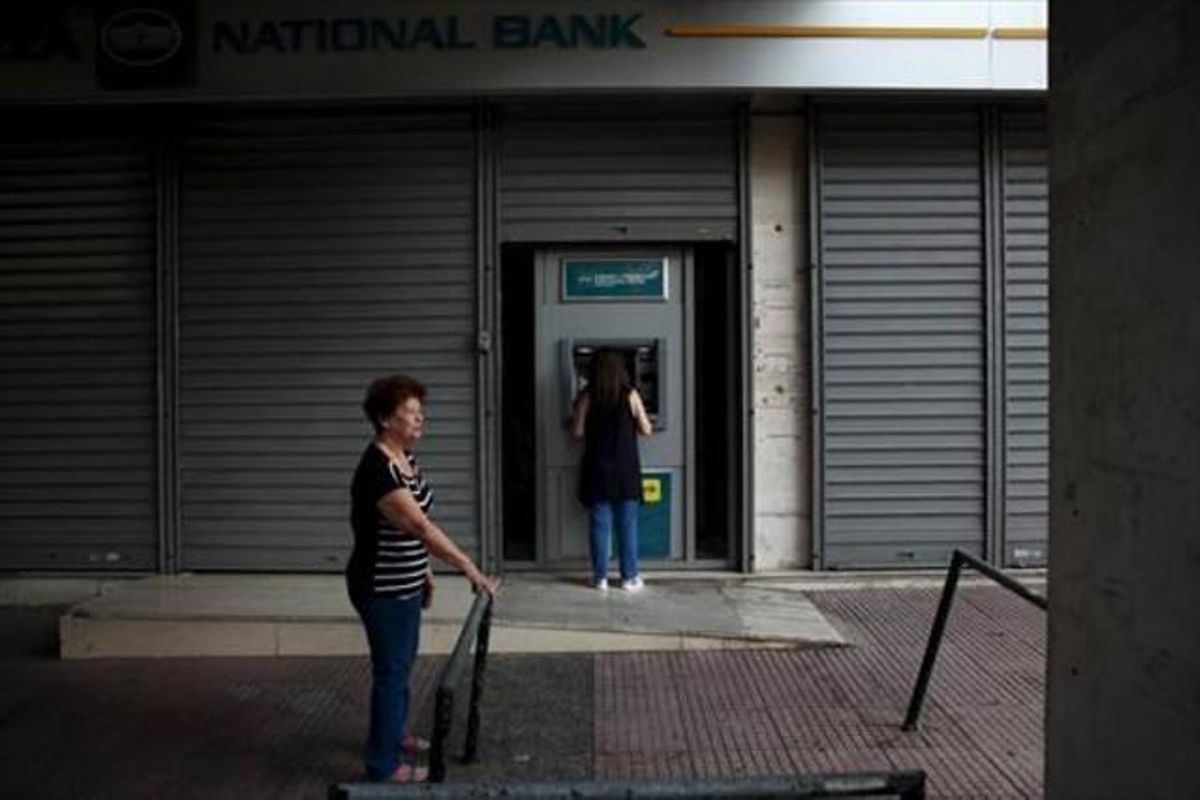 Una mujer retira dinero de cun cajero ayer en Atenas tras tres semanas de control de capitales. Una mujer retira dinero de cun cajero ayer en Atenas tras tres semanas de control de capitales.