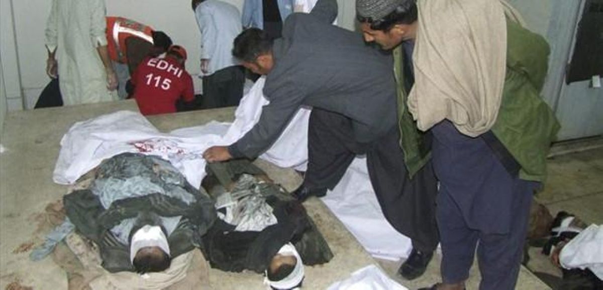 Dos hombre observan a dos de los fallecidos en uno de los atentados de Quetta. Dos hombre observan a dos de los fallecidos en uno de los atentados de Quetta.