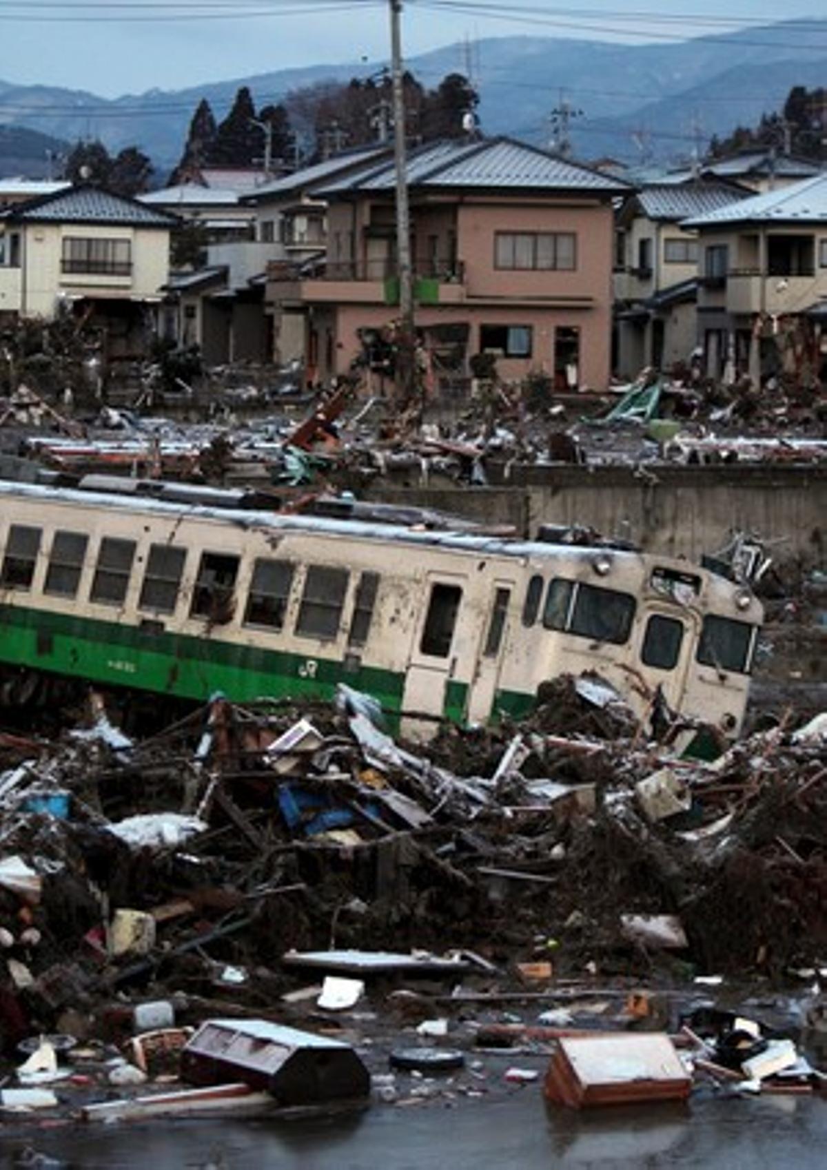El vagón de un tren y pilas de escombros tras el tsunami causado por el terremoto del pasado 11 de marzo en la ciudad de Kisenuma, Japón.
