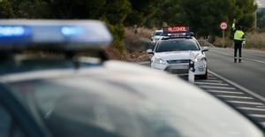 Un agente de la Guardia Civil da el alto a un vehículo en un control de tráfico.