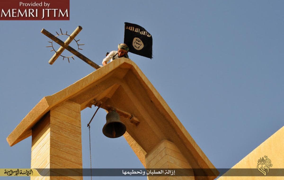 Terroristas del Estado Islámico colocan su bandera en una iglesia cristiana en el norte de Irak.