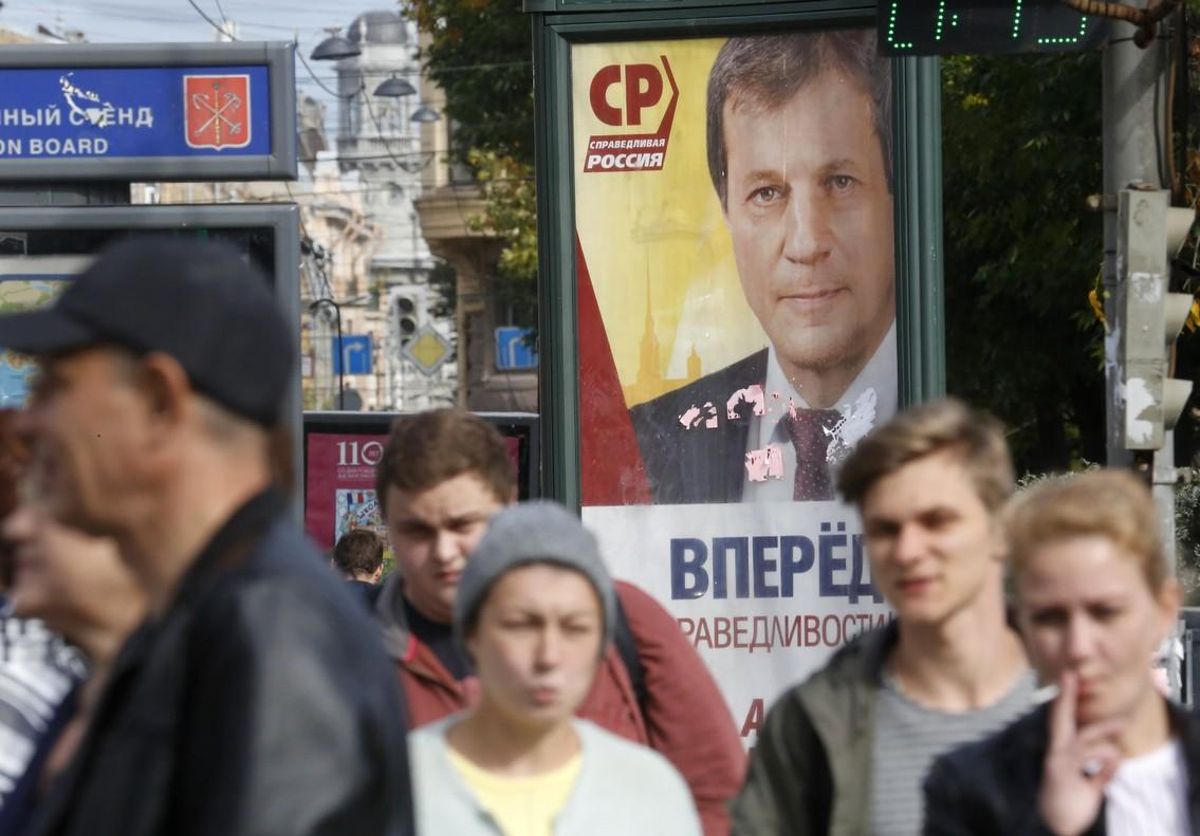 Peatones pasas por delante de un cartel electoral en San Petersburgo. Peatones pasas por delante de un cartel electoral en San Petersburgo.