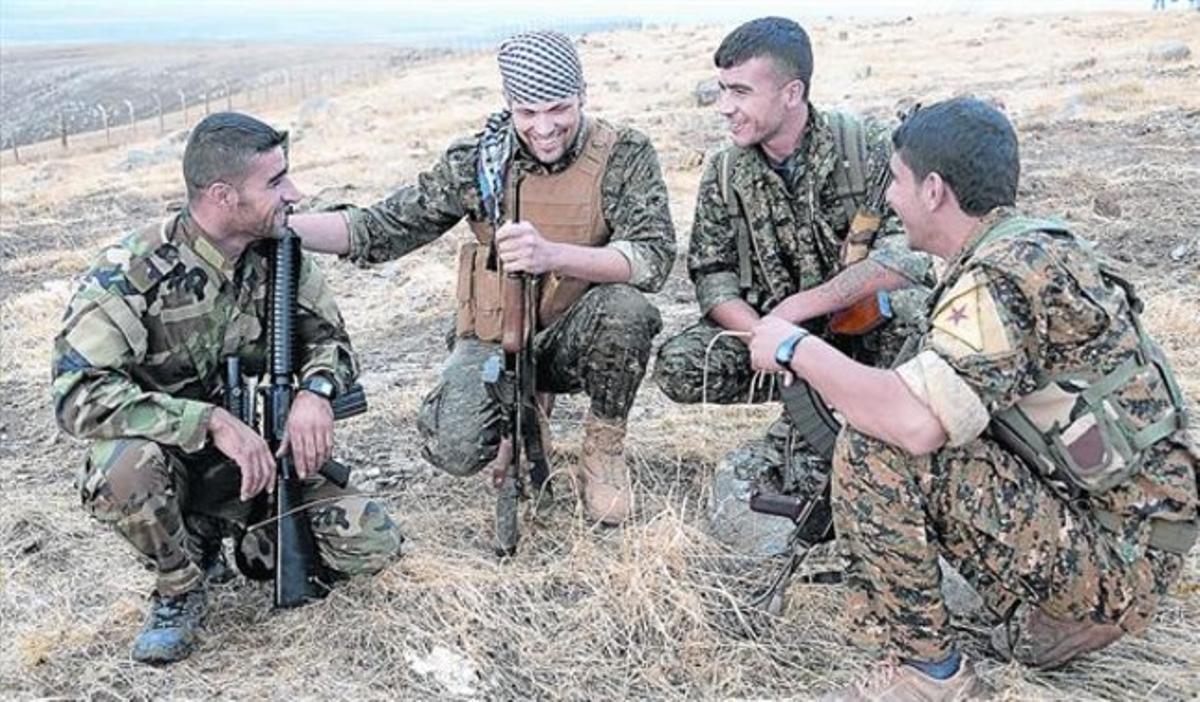 El combatiente 8 Jordan Matson, el segundo por la izquierda, junto a varios combatientes kurdos.