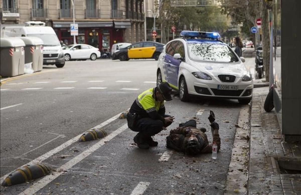 Un agente de la Guardia Urbana atiende a un ciclista accidentado en Consell de Cent con Girona, el pasado noviembre. Un agente de la Guardia Urbana atiende a un ciclista accidentado en Consell de Cent con Girona, el pasado noviembre.