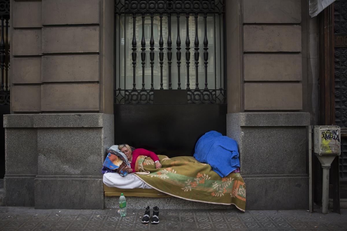 Una mujer sin hogar durmiendo en un portal en Barcelona. Una mujer sin hogar durmiendo en un portal en Barcelona.