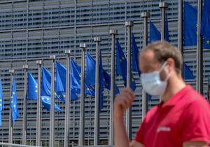 Un hombre con mascarilla, ante la sede de la Comisión Europea, en Bruselas.