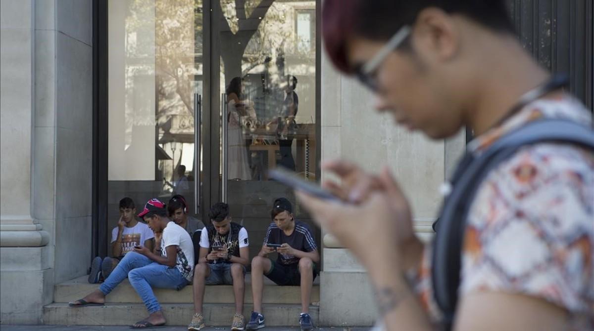 Jóvenes con sus móviles, en Barcelona.
