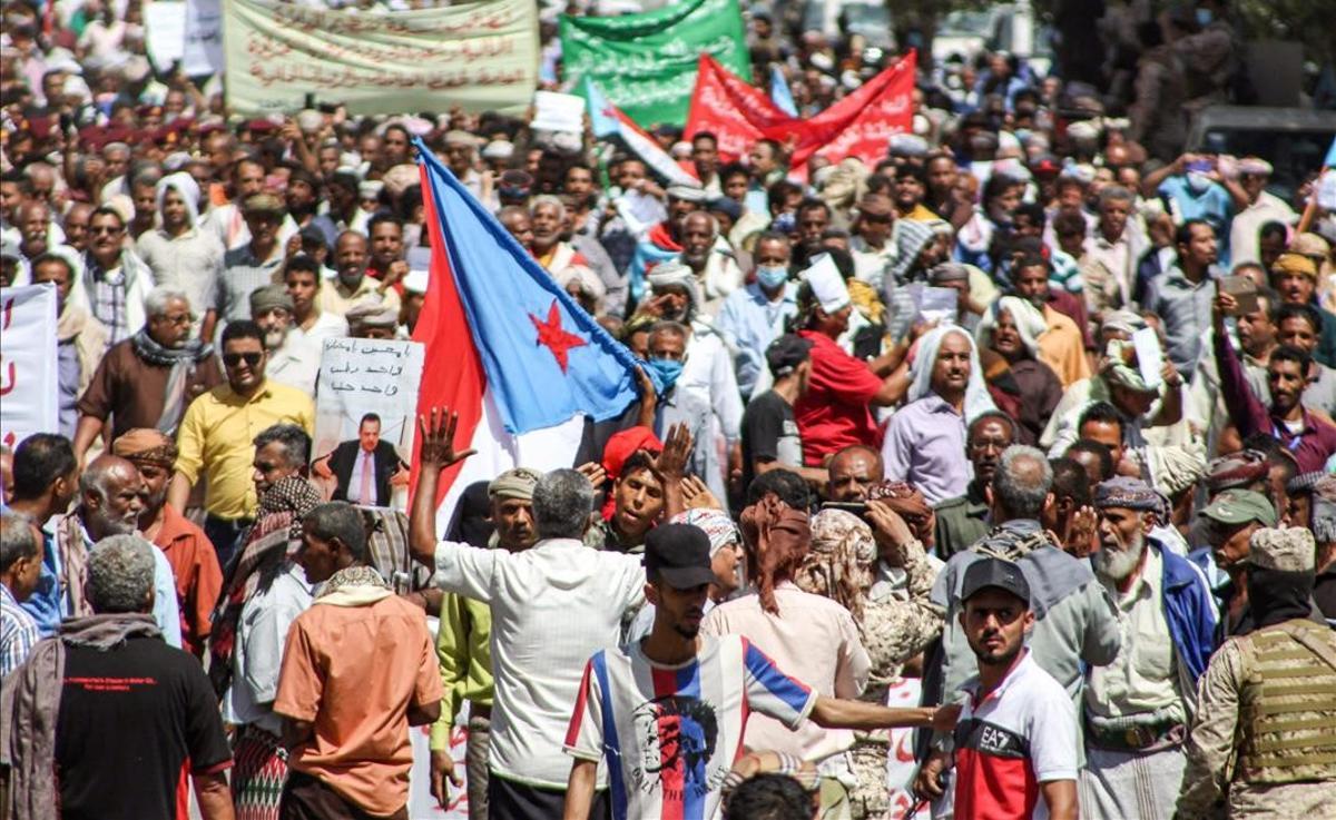 Manifestantes con banderas a las afueras del Palacio Presidencial de Aden. 