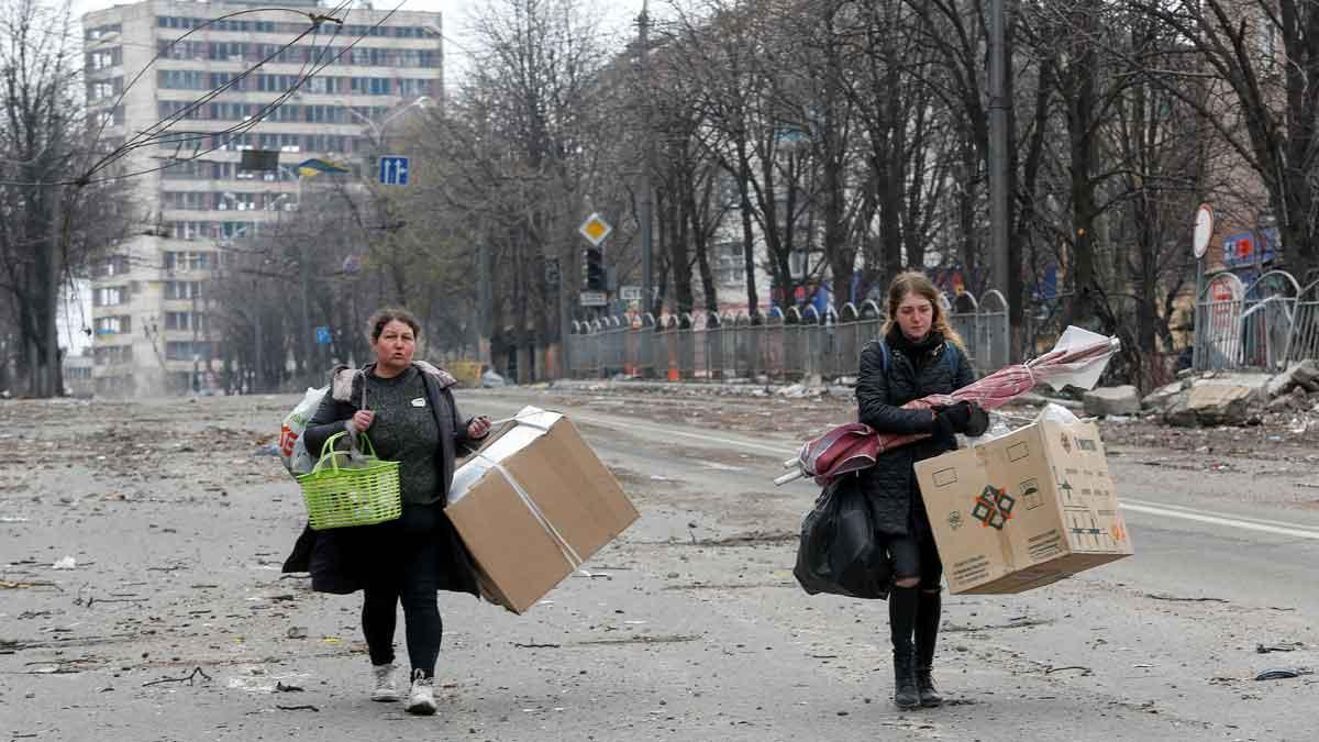 Dos mujeres trasladan sus pertenencias, en una calle de la ciudad ucraniana de Mariúpol.