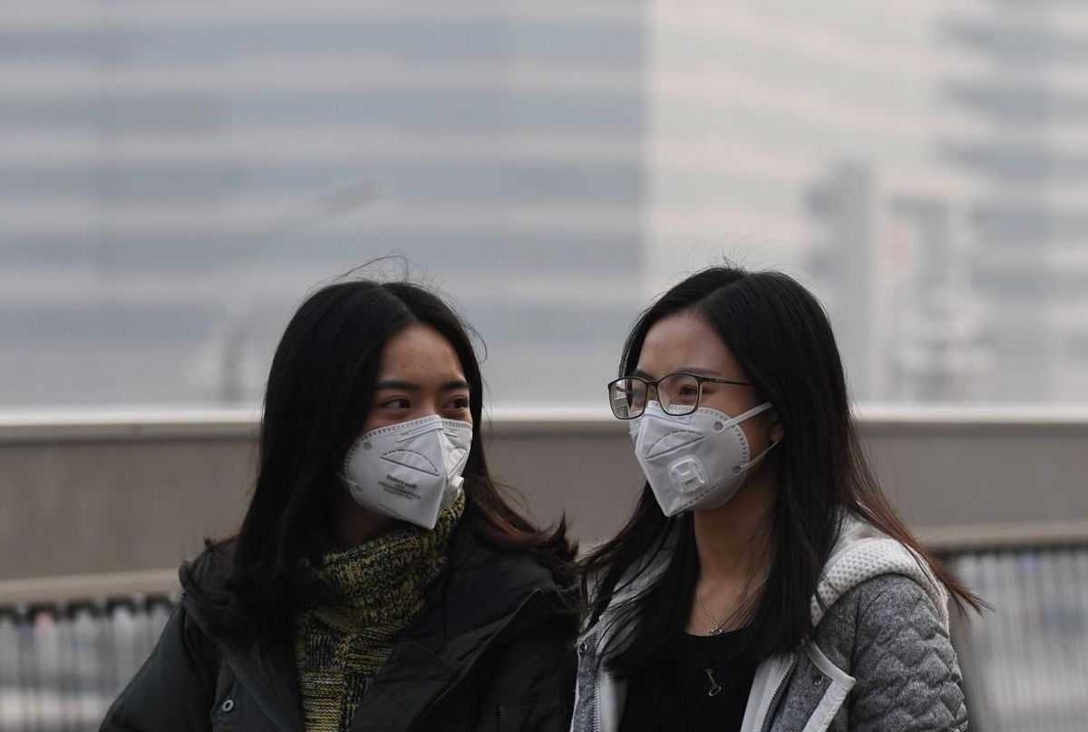 Dos chicas se protegen de la contaminación en Pekín, en una imagen de archivo. Dos chicas se protegen de la contaminación en Pekín, en una imagen de archivo.