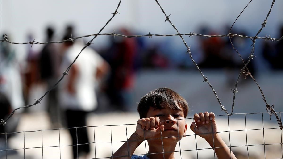 Un niño, en el nuevo campo de refugiados temporal levantado en la isla griega de Lesbos, el 23 de septiembre. Un niño, en el nuevo campo de refugiados temporal levantado en la isla griega de Lesbos, el 23 de septiembre.