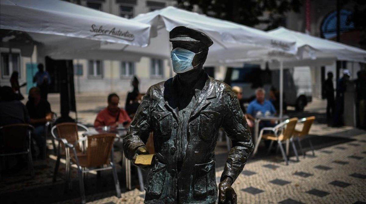 Una estatua con mascarilla en el centro de Lisboa. 