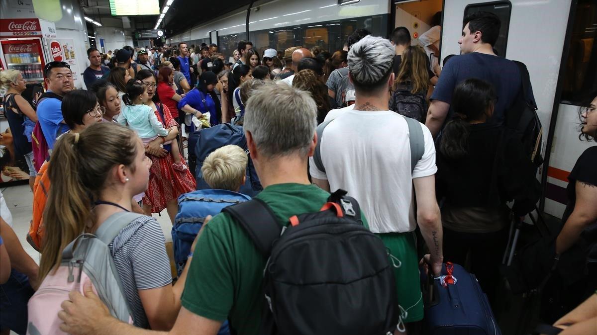 Un centenar de viajeros intenta subir a uno de los trenes de ’Rodalies’ durante la huelga convocada por el sindicato CGT, esta mañana