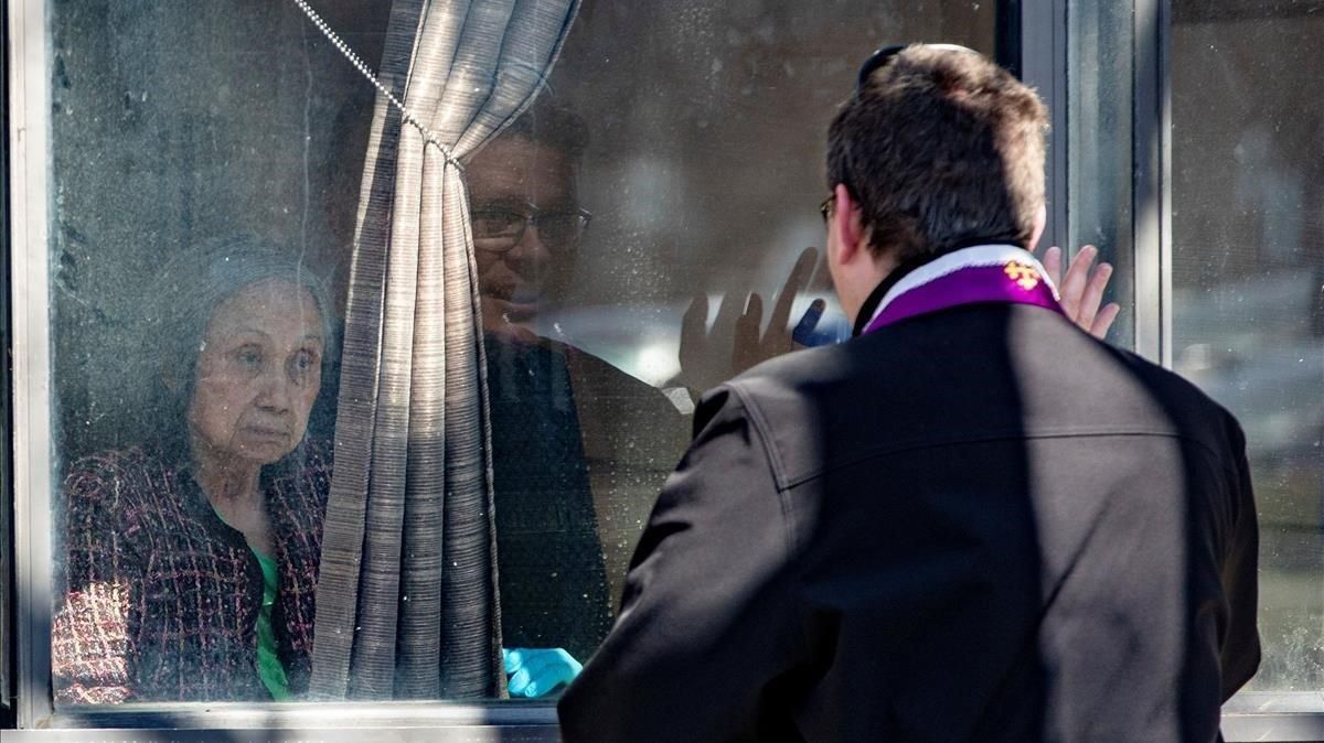 Un sacerdote bendice a Flora, residente de un geriátrico de la ciudad canadiense de Ontario donde varias personas han fallecido por coronavirus. Un sacerdote bendice a Flora, residente de un geriátrico de la ciudad canadiense de Ontario donde varias personas han fallecido por coronavirus.