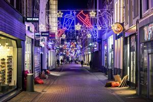 Una calle vacía en el centro de Ámsterdam, decorada con luces navideñas.