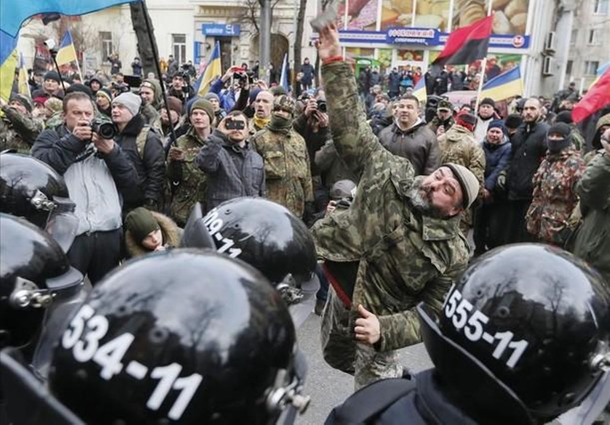 Manifestantes lanzan piedras a un banco ruso en un acto de protesta en Kiev. Manifestantes lanzan piedras a un banco ruso en un acto de protesta en Kiev.