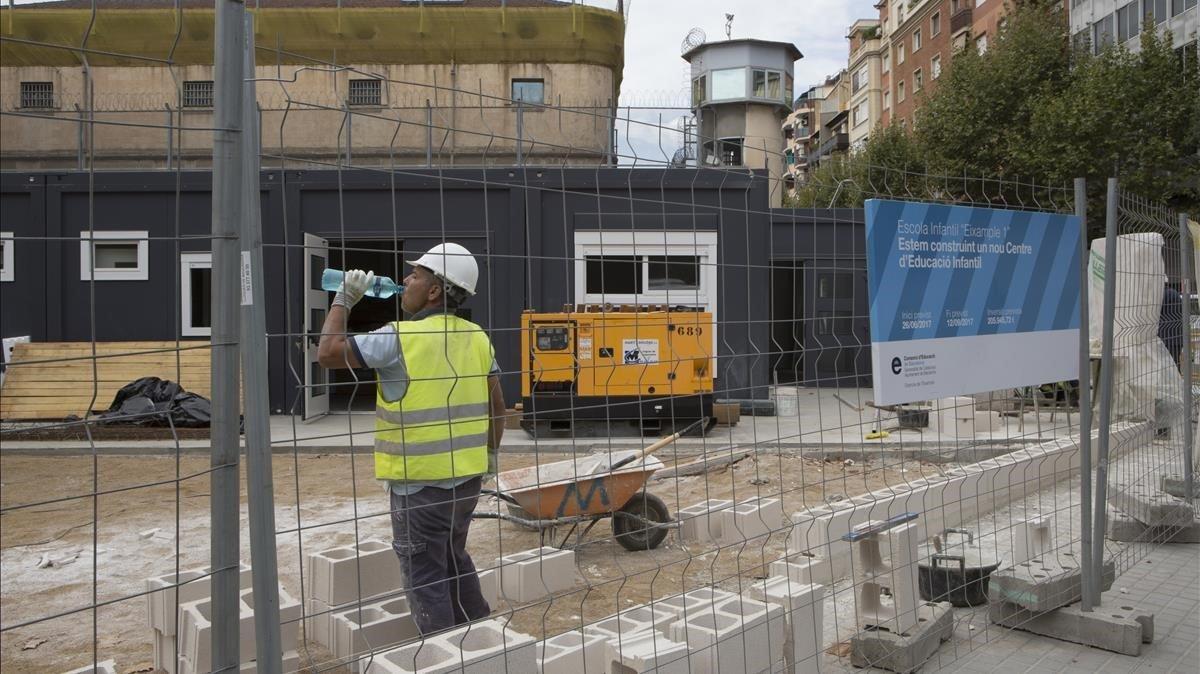 Un operario trabaja en la instalación de unos módulos prefabricados en una nueva escuela de Barcelona.