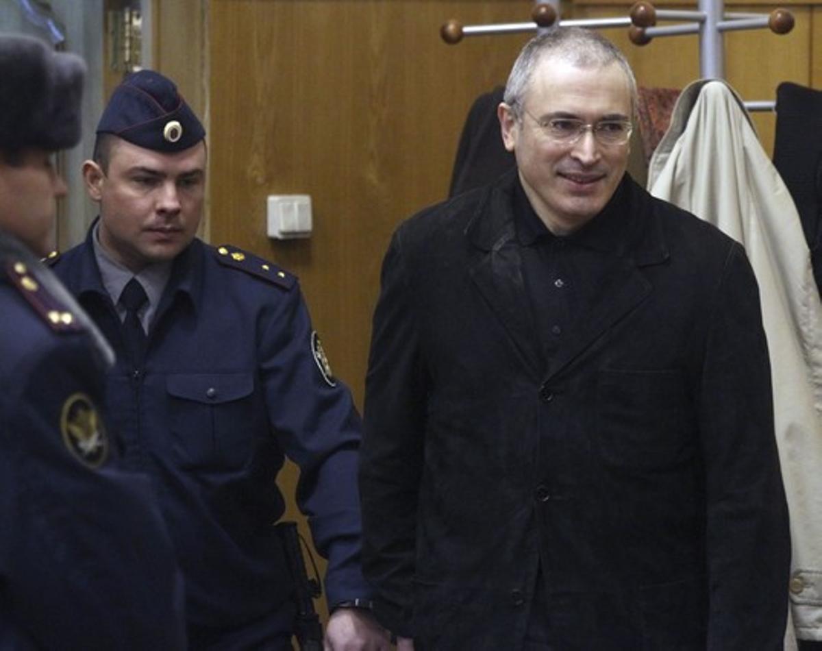 Mijail Jodorkovski (derecha) sonríe al llegar al tribunal que le juzga en Moscú, ayer.