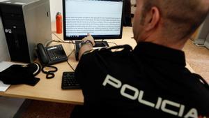 Un policía nacional revisa los mensajes de un caso de sextorsion. 