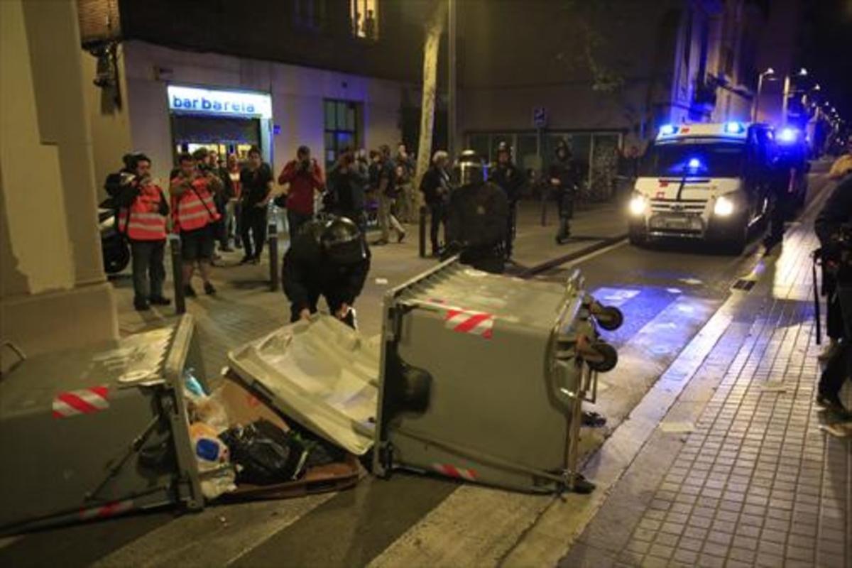 Contenedores tumbados y coches de la policía en Gràcia, la noche del martes.