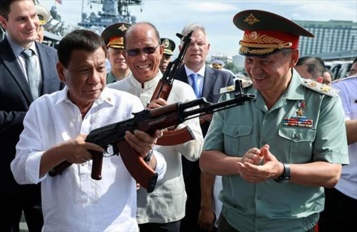 Duterte prueba un kalashnikov con el ministro ruso Sergei Shoigu.