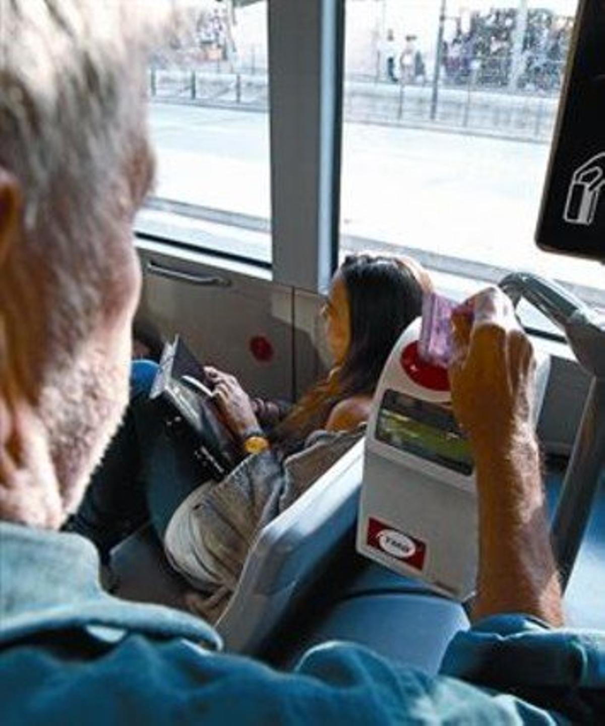 Un jubilado utiliza su tarjeta rosa en un autobús de TMB, ayer.