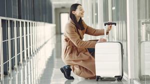 Una mujer con su maleta en un aeropuerto.