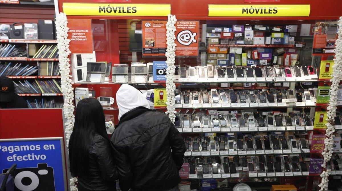 Dos jóvenes, en un establecimiento de venta de artículos electrónicos.