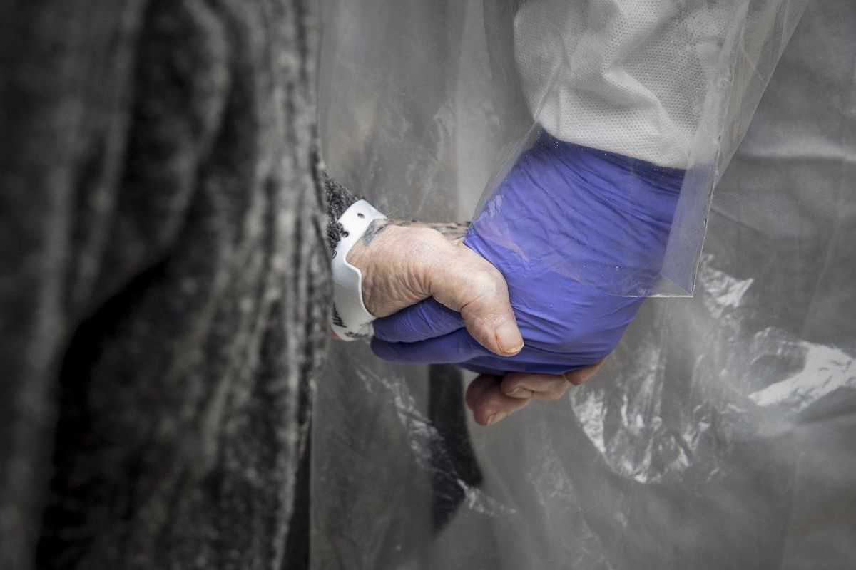 Un sanitario sostiene la mano de una persona mayor. Un sanitario sostiene la mano de una persona mayor.
