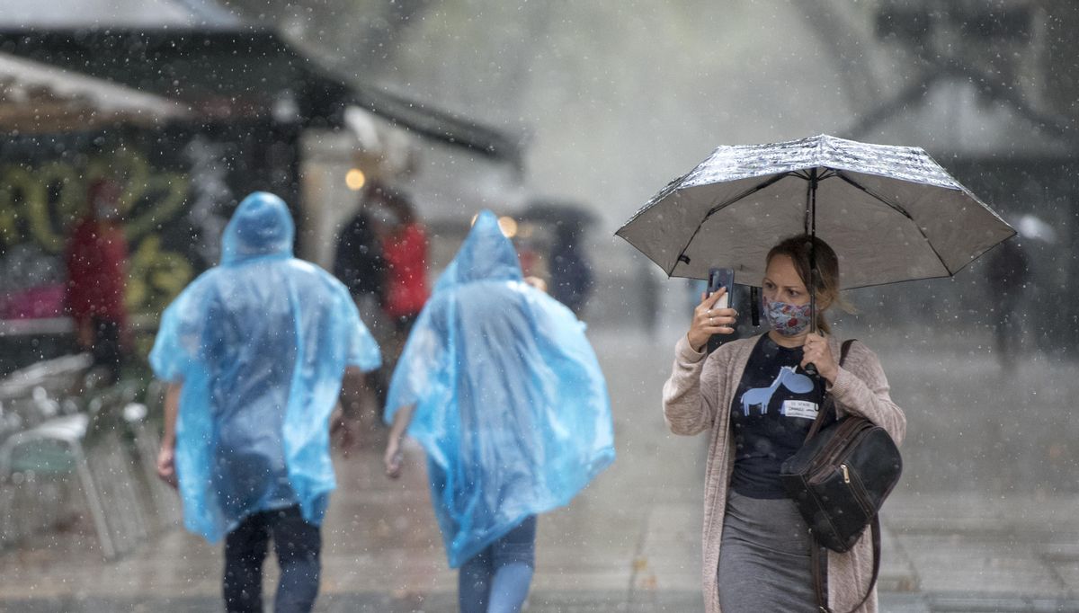 Paseantes por las Ramblas de Barcelona se protegen de la lluvia en 2020. Paseantes por las Ramblas de Barcelona se protegen de la lluvia en 2020.