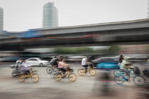 Personas montan en bicicleta en el distrito de Chaoyang, en Pekín. 