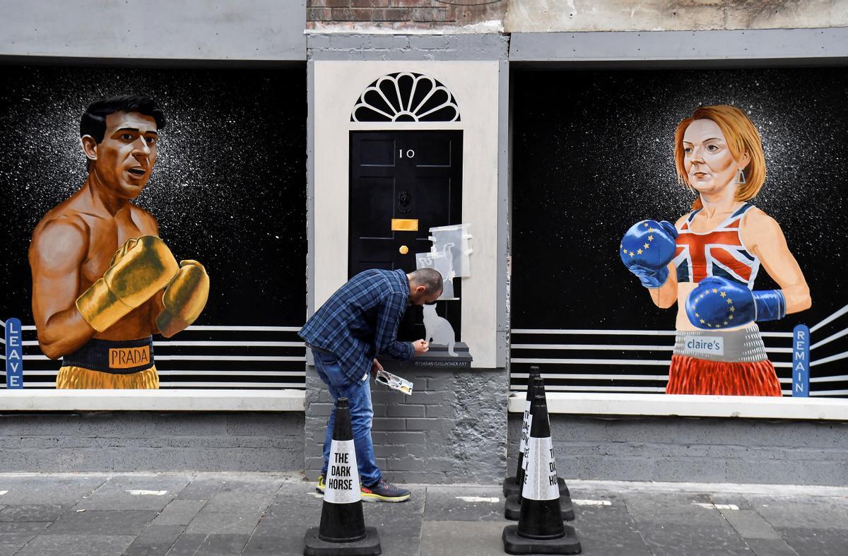 El artista Ciaran Gallagher finaliza su mural de los candidatos a liderar el Partido Conservador, Rishi Sunak y Liz Truss, este miércoles en Belfast.