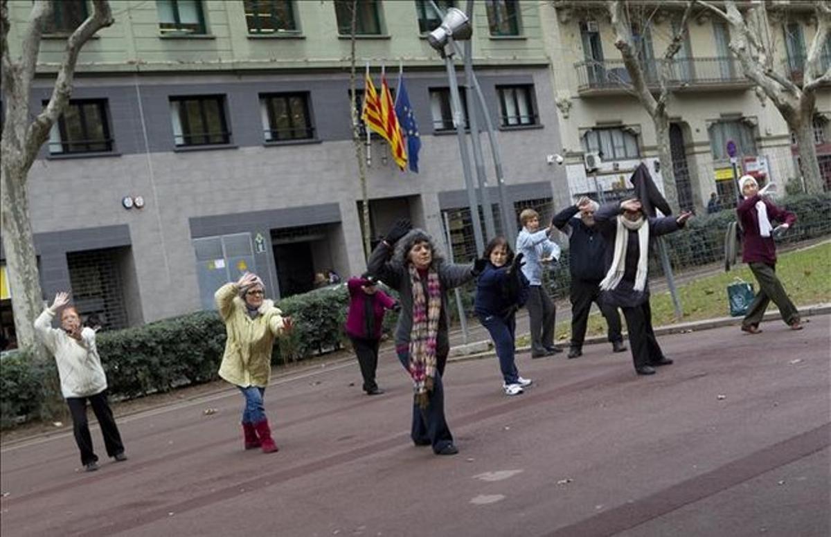 Un grupo de personas mayores practica taichí en paseo de Sant Joan de Barcelona.
