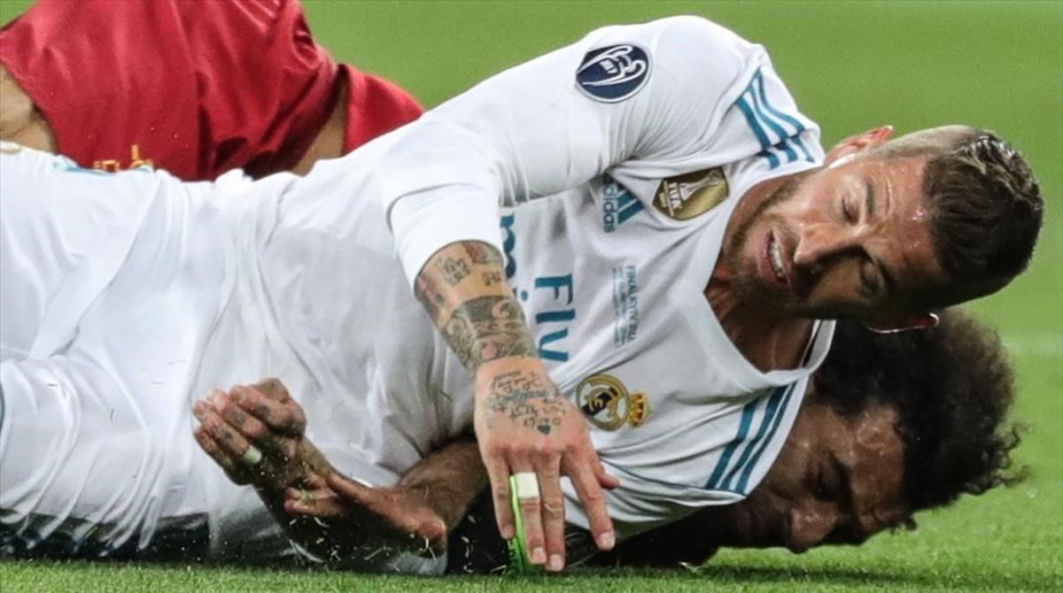 Sergio Ramos cae sobre Salah tras la disputa de un balón y le lesiona.