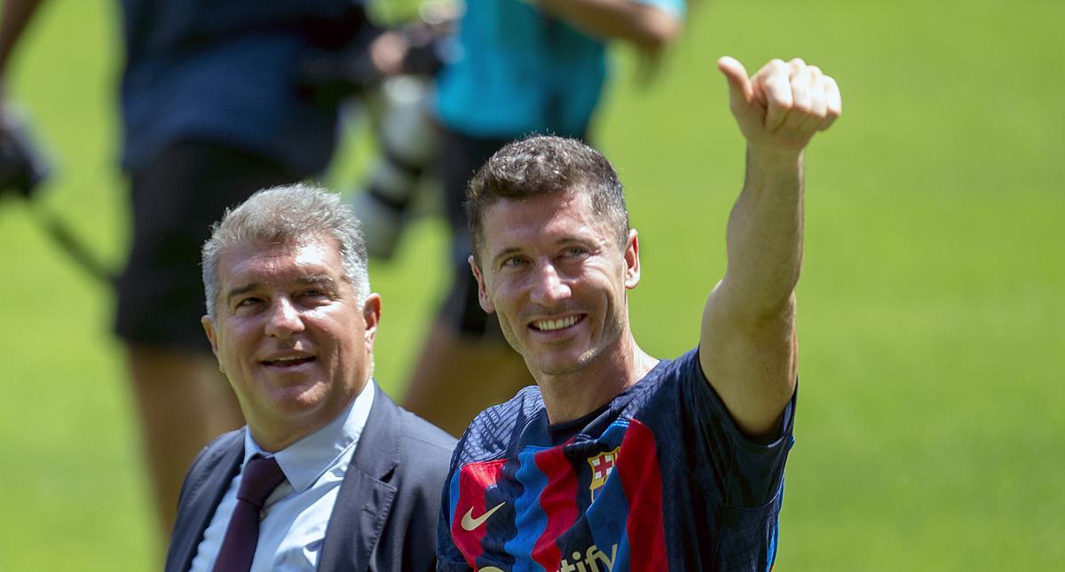 Robert Lewandowski sobre el césped del Camp Nou junto al presidente Joan Laporta.