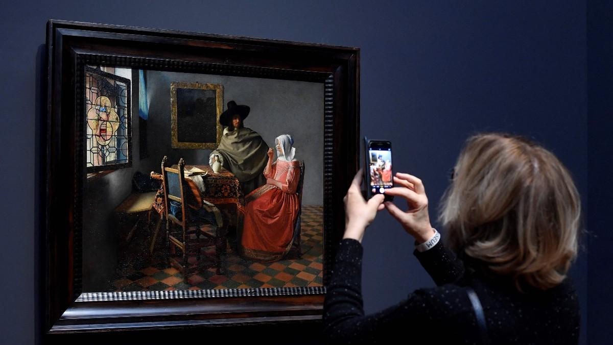 Una mujer observa ’Dama bebiendo con un caballero’ de Vermeer, ayer durante la presentación de la exposición a la prensa.