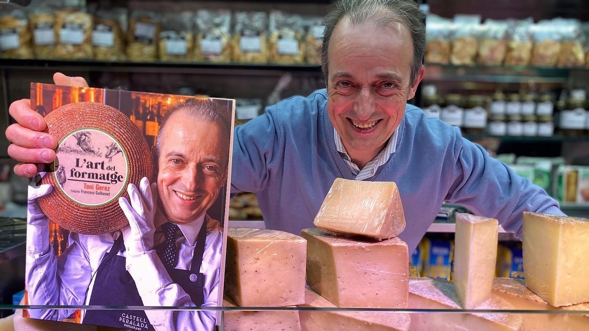 Toni Gerez, con su libro ’L’art del formatge’, en el puesto de Formatgeria Elisa del mercado de la Boqueria, este jueves.
